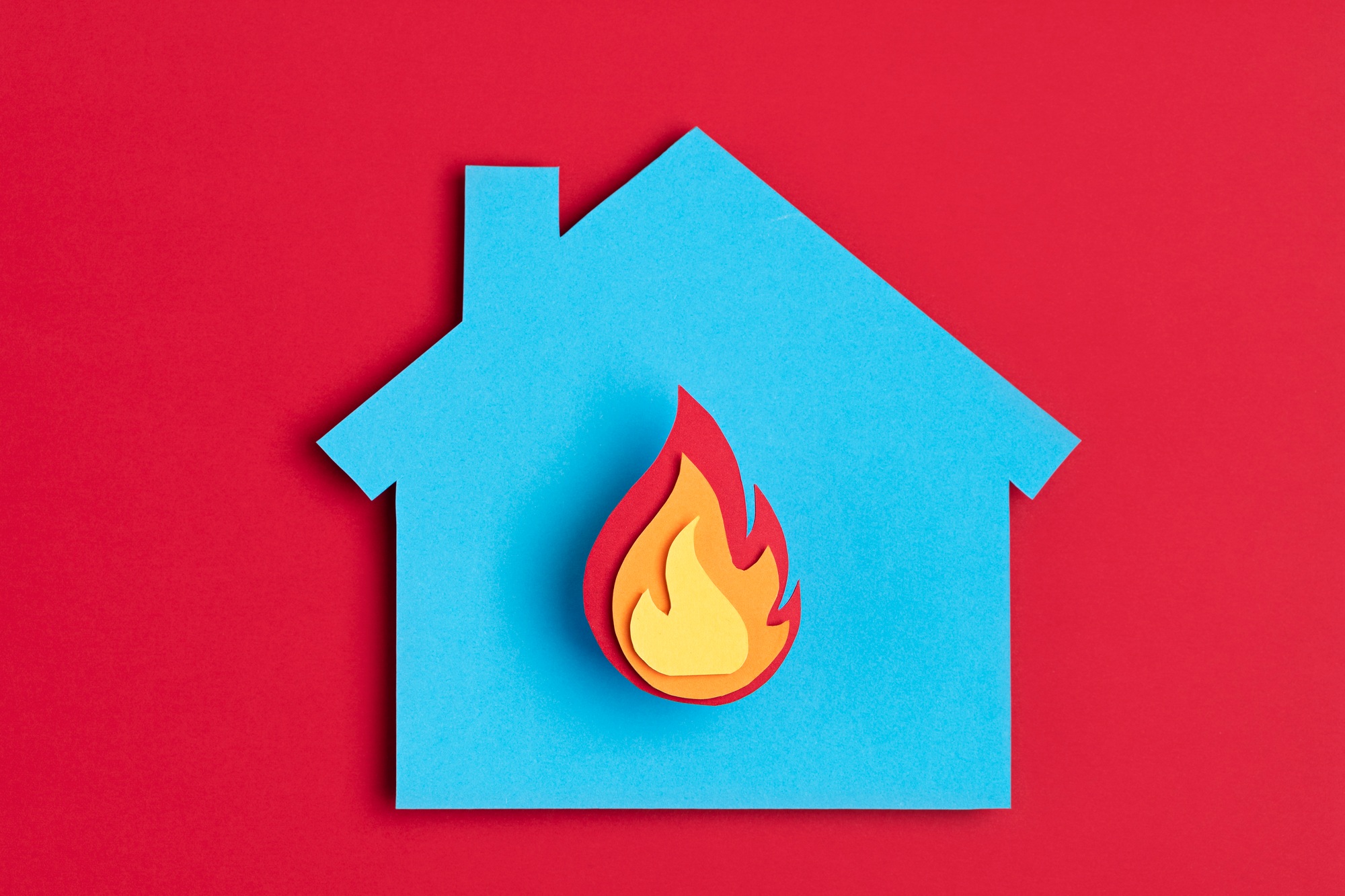 Papercut house with fire inside. Home insurance, security, safety, damage, accident prevention